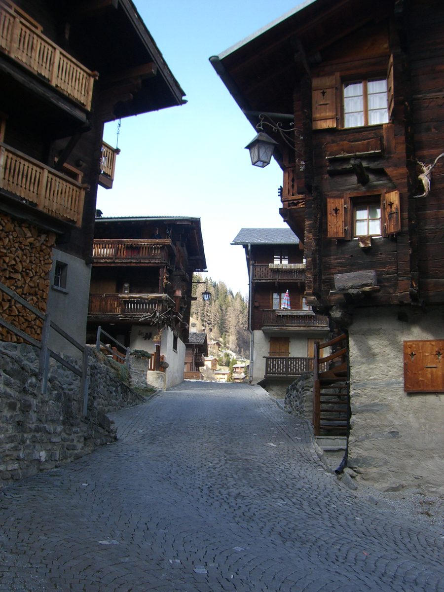 Narrow historic alley with traditional wooden houses in Grimentz in Valais