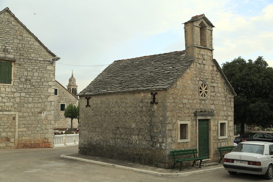 Church of All Saints in Pražnica in front of the post office and the local grocery shop