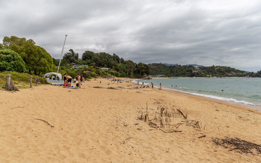 Sandy beach at Little Kaiteriteri with calm blue water.