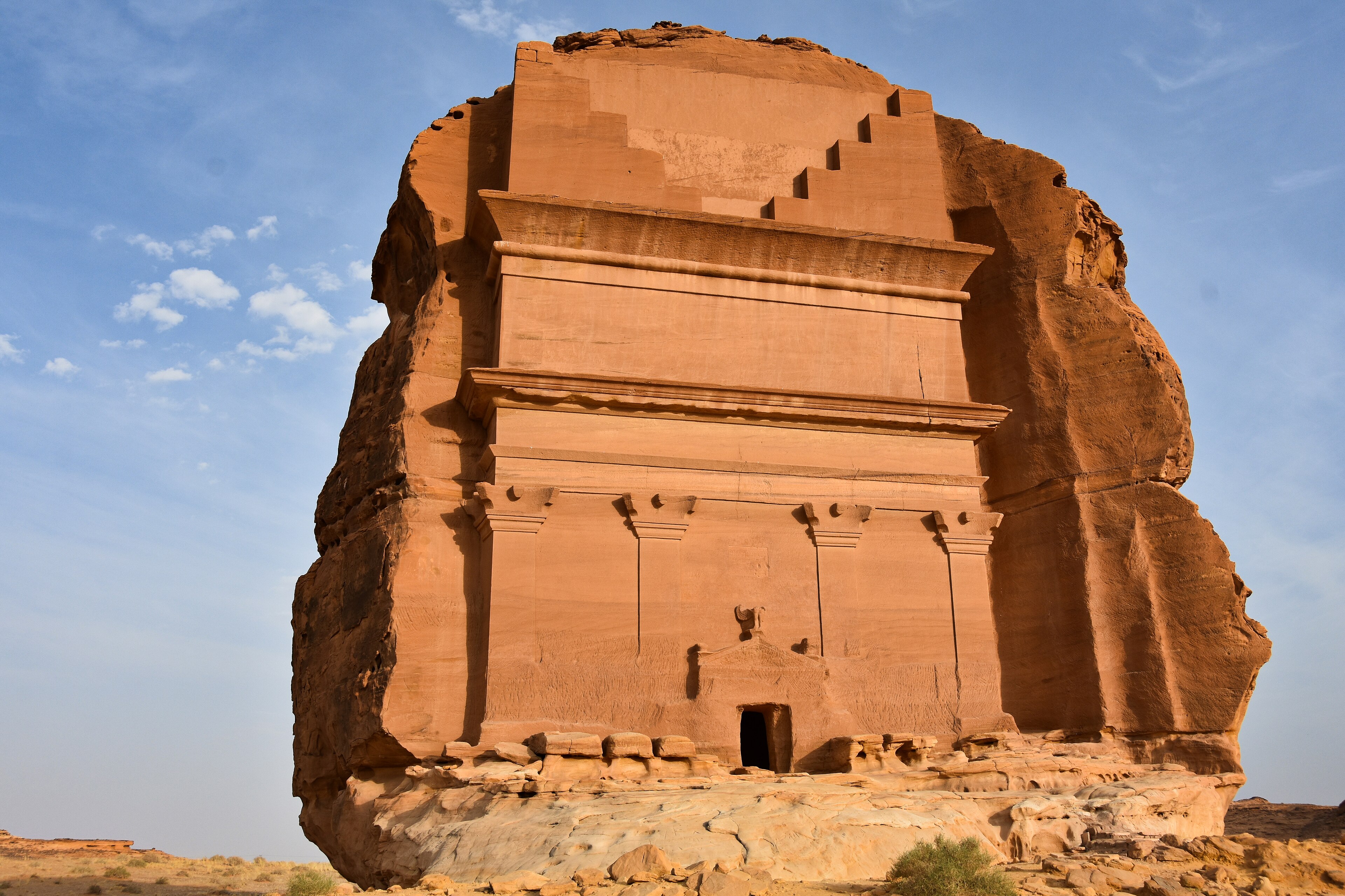 Freestanding Nabataean tomb carved into a sandstone cliff in Hegra