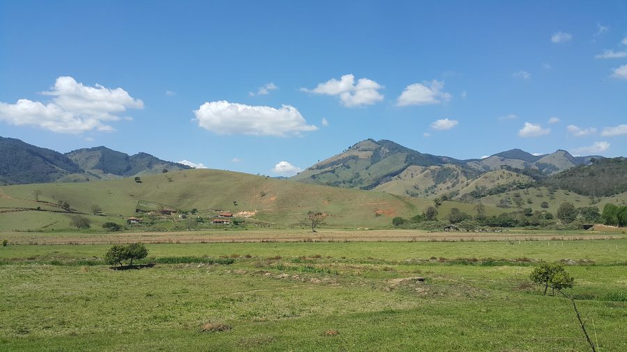 Hilly countryside in Minas Gerais beside a highway.