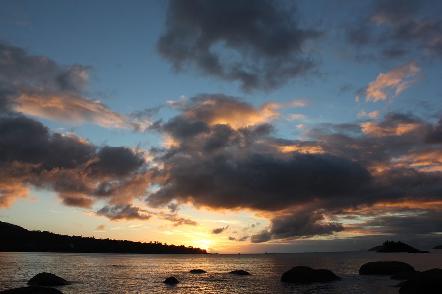 Praia Julião in Ilhabela, São Paulo, at sunset, with the coast and the island's vegetation